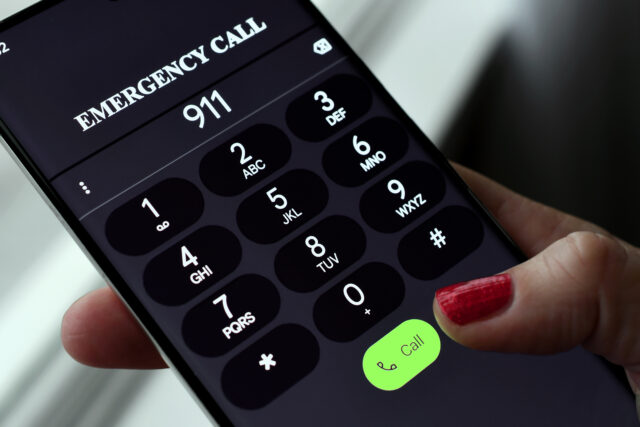 Stock photo of caller dialing 9-1-1.